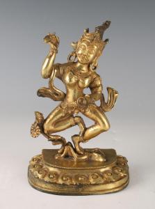 Bronze goddess statue shown standing atop a human figure, wearing jewels, a headdress and holding a vajra, 7 ½ inches tall (est. $400-$600).