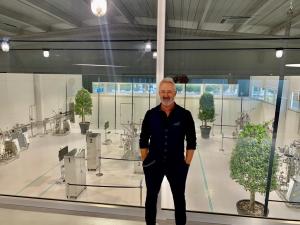 MD Matteo Brognoli at Solaris Biotech Industrial facility in Porto Mantovano, Italy. He stands in the lobby and we can see thru the large glass wall all industrial bioreactors being assembeld and prepared for validation test.