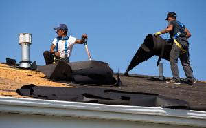 Latino construction workers rebuilding a roof