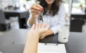 Woman's hand handing over house key