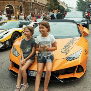 Two young girls pose with a gorgeous Ferrari taking part in The Rally.