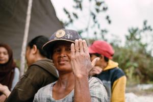 Traceable gold supply chain - Female gold miner showing finished gold jewelry