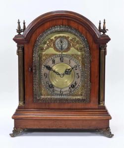 Reloj de sobremesa Tiffany & Co. Westminster del siglo XIX con caja de madera y cuatro remates de latón que albergan una esfera que representa elementos de amorcillos y zarcillos (estimado entre $2500 y $3500).