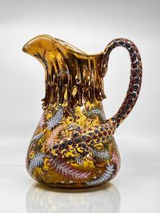 Circa 1890 Moser gilded and enameled pitcher in pale olive-green glass, 10 ¾ inches tall, with an applied scroll handle in the form of a salamander (or lizard) (est. 800-$1,200).