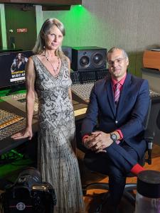 Elegant lady in gown and gentleman in suit, seated in recording studio