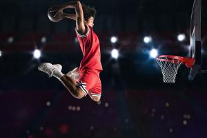 The image is of a basketball player getting set to score with a spectacular slam dunk.