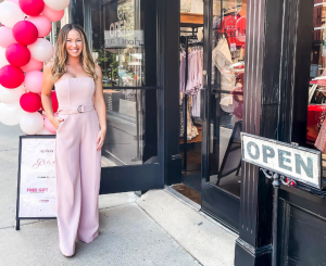 A female business owner in front of her new Apricot Lane Boutique on grand opening