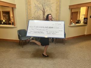 An elated Dr. Erin Bendas celebrates a generous check from the Judith Adele Agentis Charitable Foundation