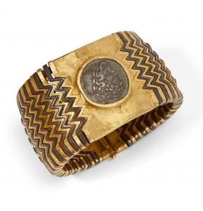 22 karat gold and steel bracelet with a silver central piece in the style of the Greek tetradrachm from the 3rd century BC.  AD, surrounded by a broad zig-zag pattern of alternating gold and steel links, engraved Siragusa (est. $3,000-$5,000).