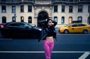 Adeline V. Lopez in a NYC street, with a taxi going by