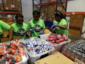 Embrace Girls Foundation members pack relief supplies at GEM headquarters.