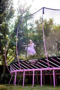 Girl jumps on limited edition pink trampoline from Springfree Trampoline in partnership with Susan G. Komen.