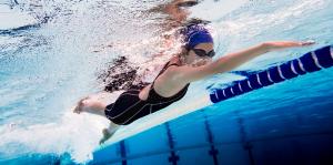 Woman swimming with Freestyle headset by Conduction labs to bring sound to her swimming exercise