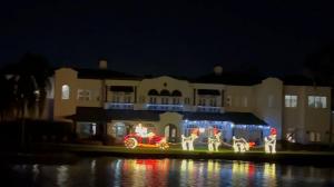 Santa Clause driving a car decked in Christmas lights onThe Winter Park Old Fashioned Christmas Cruise!