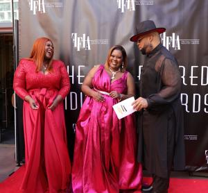 Red Carpet Hosts Leah Nicole (red pantsuit) and Nathaniel Jaye (black suit with hat) interview Full Figured Industry Awards Founder Tawana Blassingame (pink suit).