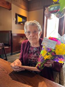 Women at her 100th birthday party with flowers