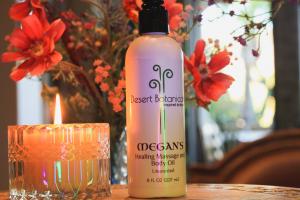 Bottle of Megan's Healing Body and Massage Oil with candle