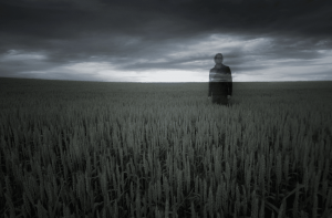 Man standing in field contemplating what to next