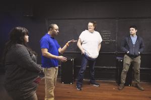 4 players in a black box theatre standing in a semicircular discussing improv. Players are: Annica Eagle, Frank Tano, Kait Concilio, and Michael Winser.