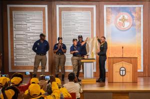 Chairperson of the Scientology Volunteer Minister, Sandile Hlayisi and Tshwane Metro Police Officers unveiling the Bronzed Police Cap and Plaque.