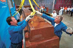 World’s Finest Chocolate employees attach straps to a cart holding a 12,000-pound chocolate bar so that it can be hoisted and weighed for the official Guinness World Records judging. Photo by: Courtesy World’s Finest Chocolate