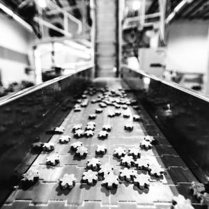 Black and white conveyor belt image with PetDine soft chews in production.