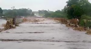 Dark floodwaters wash across a bridge in Malawi.