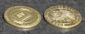 Selbstgeprägte Münze. Vorderseite mit Logo von AV-Comparatives. Rückseite mit Schriftzug Hasegg Castle Mint Hall und Adler.