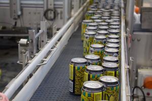 A photo of WISEACRE's packaging line shows cans of Tiny Bomb with colorful design.