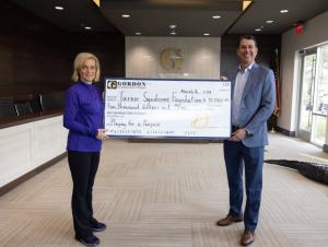 Gordon McKernan and Coach Kim Mulkey pose together at a check presentation marking the culmination of McKernan’s “Playing for a Purpose” campaign.