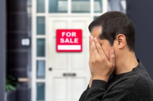 Man extremely depressed and sad about losing his house key and seeing a for sale sign