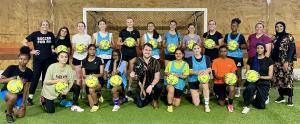 Picture of the #SheBelongs Team First Training Session in front of the Goal holding soccer balls