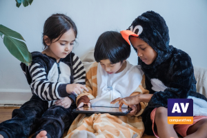 Three children in costumes playing together on a tablet and a Logo von AV-Comparatives