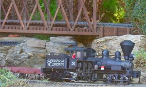 A shay Loco passes under a Trestle