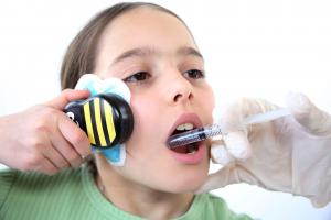 Girl getting dental injection, self-applying Buzzy