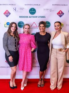 Photograph of 4 women in front of the banner on a red carpet. They look forward smiling. From left to right are: Michelle Galluf, Ana Silvani, Vera Jimenez and Suzana Pires.