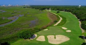 View of the 4th Hole at Tidewater Golf Club, a scenic golf course surrounded by lush greenery and water hazards.