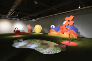 An artwork of statues depicting the garden on Spring at the Culture Pavilion at Gwangju Design Biennale. From the left: a red flower with bent stem, a red flower, sun, mountains, a red flower. | Photo by AVING News
