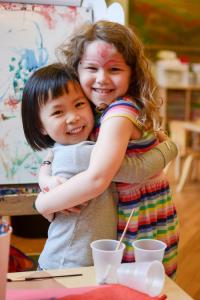 Two children from Imagine Early Learning Centers hugging in a classroom
