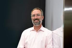 Photo of Matt Wright, SVP of Customer Success, AppZen, with white shirt, salt and pepper beard, and glasses