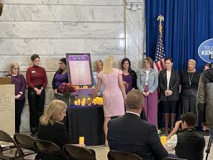 First Lady Britainy Beshear places a candle on a table with other candles, symbolizing a life lost to domestic violence, during the Domestic Violence Awareness Month Proclamation Signing's Speak My Name ceremony on October 18, 2023 at the State Capitol Ro