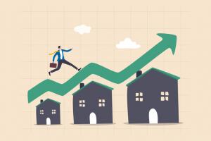 Housing price rising up, real estate or property growth concept, businessman running on rising green graph on house roof