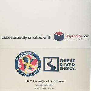White Box with ShipThrifty, Maple Grove Beyond the Yellow Ribbon, and Great River Energy logos printed on it.