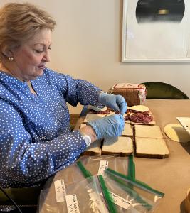 Peggy O'Brien, resident at Inspīr Carnegie Hill, prepares sandwiches for donation.