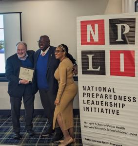 Leonard Marcus (l) names Marcus Coleman (c) Meta-leader of the Year 2023. Coleman is joined by his wife, Amber English Coleman