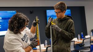 Two students learn to measure pipe