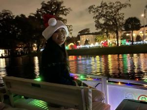 Female guest enjoying the lights, sounds and flavors on Original Orlando Tours' Winter Park Old Fashioned Christmas Cruise.