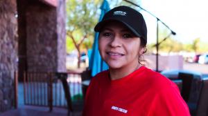 Maribel a staff member of Whats Crackin Cafe smiling on cafe's patio