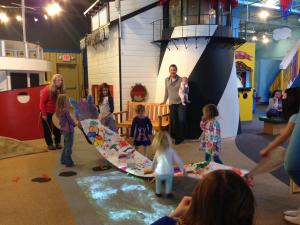 kids activity in the Great Lakes Children Museum - young kids helping hold big banner created together