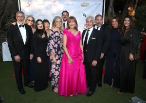 The Open Hearts Foundatin's Board, Executive Director and representatives of its Charity Partners stand against a backdrop at the 2023 Gala.